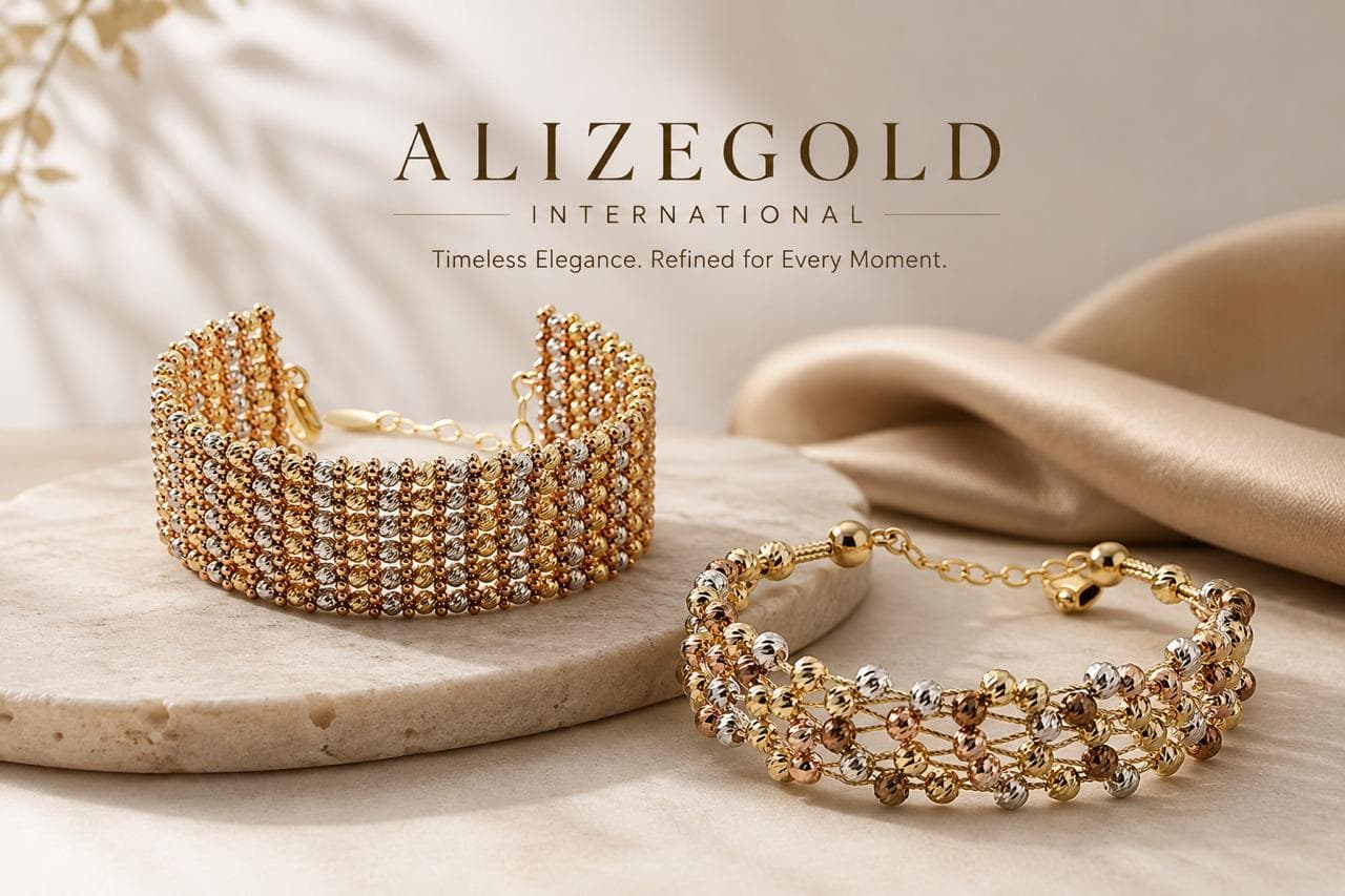 Two handcrafted multi-tone gold bead bracelets resting on travertine stone and champagne silk